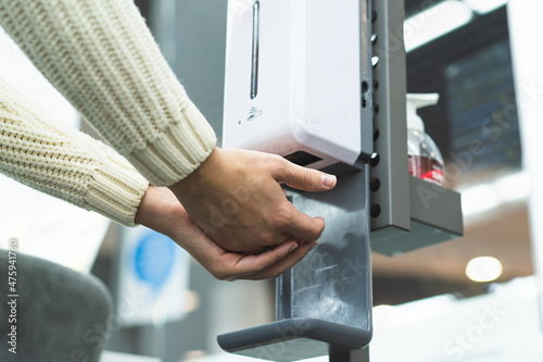 Cleaning, washing hands using automatic sanitizer dispenser concept. Today people lifestyle concept. Virus protection.