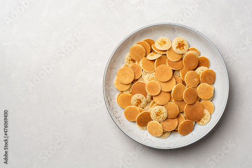 Pancake cereal or mini pancakes in plate on concrete background
