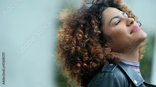 Carefree Brazilian woman closing eyes feeling freedom