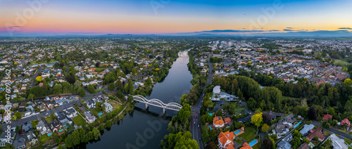 Aerial drone panoramic view at sunset, looking up the Waikato River towards the CBD, over the city of Hamilton (Kirikiriroa) in the Waikato region of New Zealand.