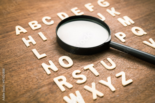 Magnifying glass in English alphabetical order from A-Z wood letters, learning English language, vocabulary and glossary, find the right word to communicate