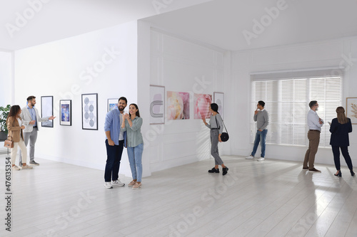 People viewing exposition in modern art gallery