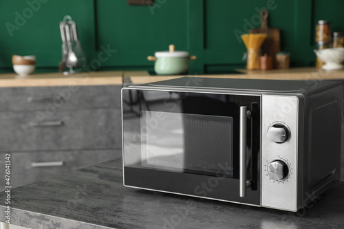 Modern microwave oven on table in kitchen