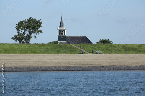 The church of the town Oudeschild on the island of Texel, the Netherlands behind the dyke 
