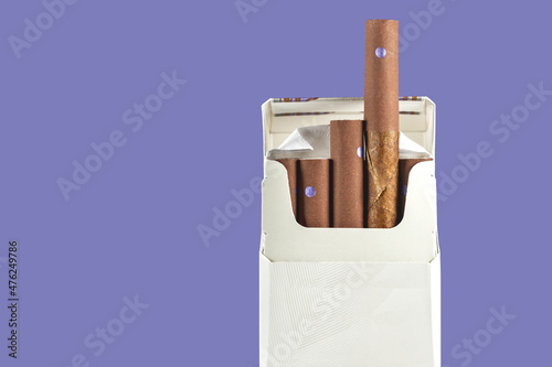 cigarillos pack on purple background copy space