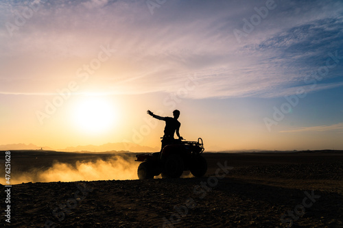 Silhouette shot of a man riding a quad bike or ATV in Hurghada, Egypt during sunset