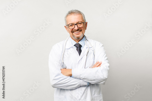 Portrait of an elderly male doctor on a white background. Friendly doctor smiling while looking at the camera.