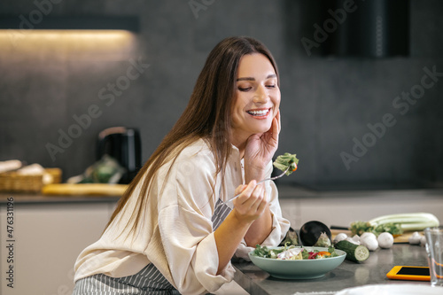 Smiling happy woman eating with appetite