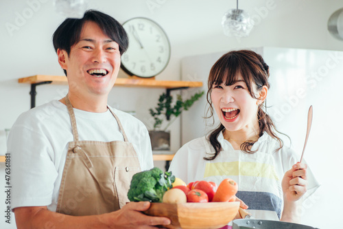 一緒に料理を作る男女（夫婦・フライパンと野菜） 