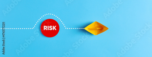 Sailing paper boat comes around the obstacle of risk. Risk avoidance in business