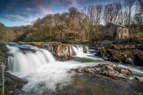 Cenarth Falls, Pembrokeshire. An autumn day, the waterfall is full. Slow shutter speed to smooth out the water