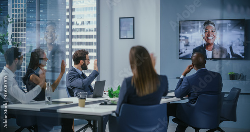 Video Conference Call in Office Meeting Room: Black Female Executive Talks with Group of Multi-Ethnic Digital Entrepreneurs, Managers, Investors. Businesspeople Discuss e-Commerce Investment Strategy