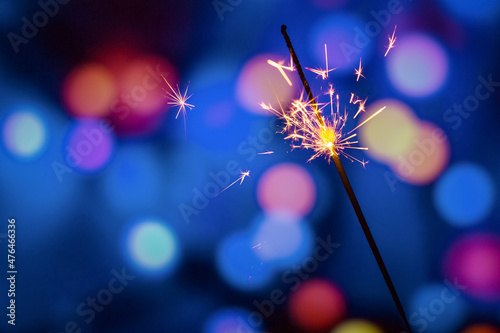 Bengal fire burning on a color blurred background. Firework salute. Festive new year background.