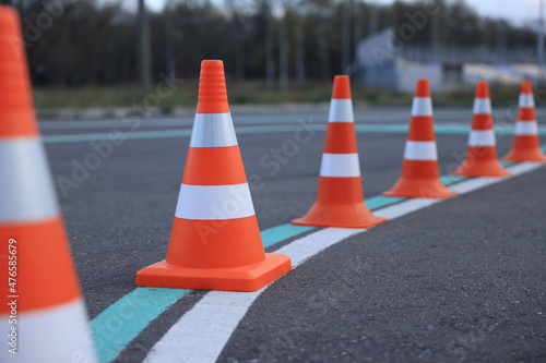 Driving school test track with marking lines, focus on traffic cone