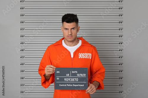 Prisoner with mugshot letter board at police department