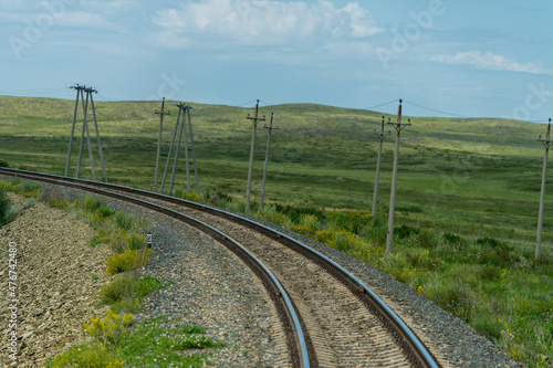 railway, railroad, rail, elevated. steppe prairie veld. is a means of transportation and passengers of trucks moving on rails that are located on the rails of the Great Plains. The steppe is great.