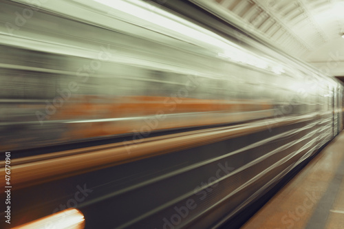 A greased train at high speed rushing past at a metro station