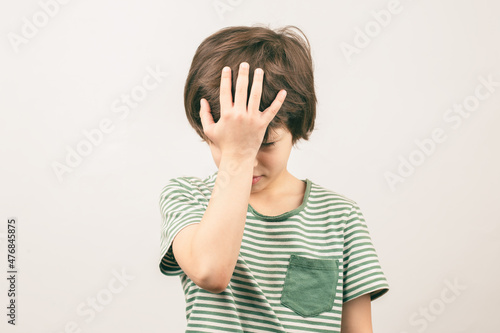 Boy placing hand on head. Face palm gesture