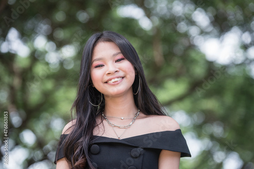A pretty young asian teenager with overbite. A darling teen in a cute black dress.
