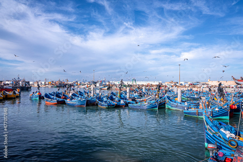Essaouira, Morocco. October 10, 2021. Small fishing boats moored on coast at port against cloudy sky, Wooden fishing boats moored in harbor