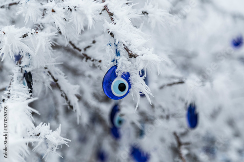 Blue evil eye, nazar boncugu, Turkish symbols hanging on a tree; Cappadocia
