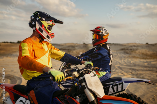 Two motocross MX riders talking before racing