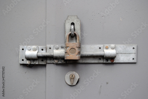 Close Up of Metal Padlock and Hasp on Grey Wooden Door