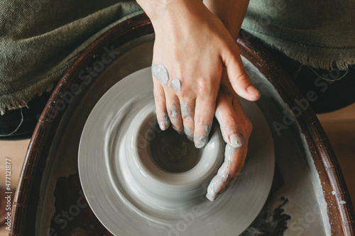 A female craftsman works in a clay workshop on a potter's wheel. The concept of creative people.