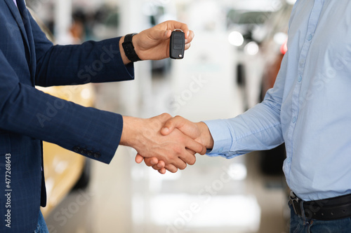 Closeup of customer and car dealer shaking hands