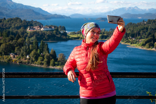 Mujer tomando una selfie en mirador del circuito chico de la ciudad de Bariloche. Patagonia Argentina