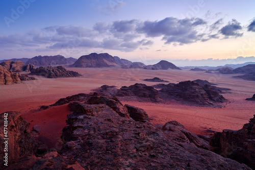 Wadi Rum desert, red sand with stone and rock. Evening orange sunset in nature. Travel Jordan, Arabia nature. Wadi Rum pik violet sunset, evening in the desert. Jordan nature landscape.