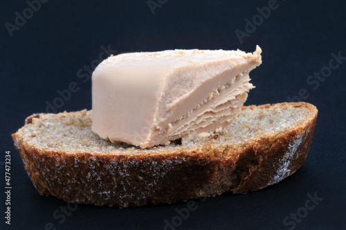 Morceau de foie gras sur une tartine de pain en gros plan sur fond noir