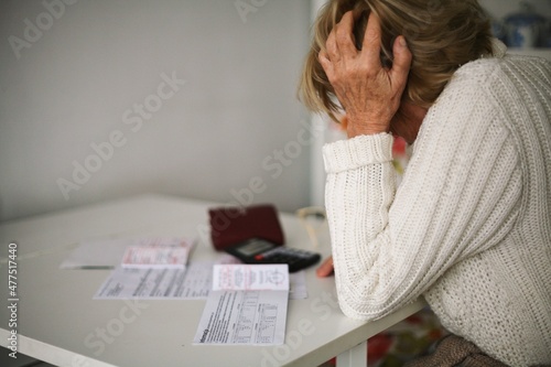 Senior sitting at the table counting bills