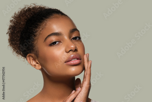 Beauty woman black skin face smiling model touching her face. Color background. Green