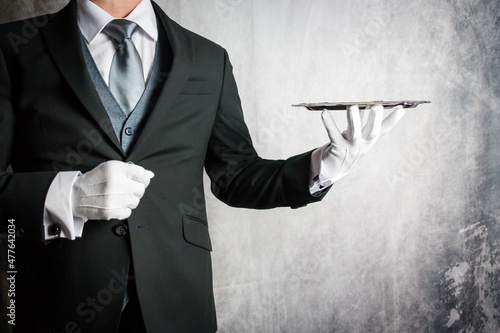 Portrait of Butler or Waiter in Dark Suit and White Gloves Holding Silver Serving Tray. Copy Space for Elegant Hospitality and Fine Dining.