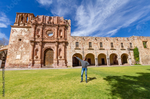 A young adult woman exhibits the facade of a very important museum in the city of Zacatecas in Mexico