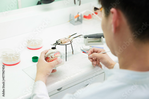 Dental technician doing partial dentures of acrylic resins in the lab.