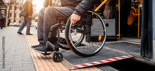 Person with a physical disability exits public transport with an accessible ramp.