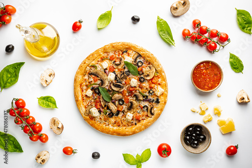 Tasty vegetable pizza and cooking ingredients tomatoes and basil on white background. Top view
