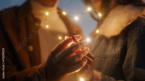 Coppia di ragazzo e ragazza si abbraccia in campagna di notte con striscia di luci led