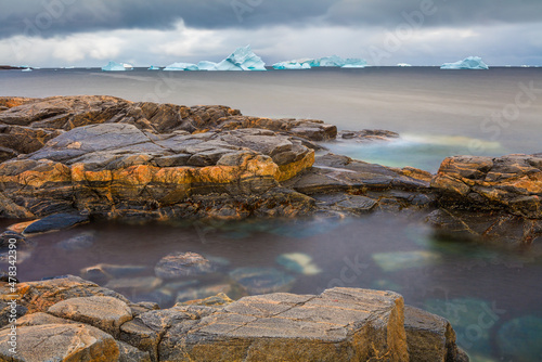 Long exposure image of a seascape with rocks and icebergs floating in the sea, Disko Island, Greenland 
