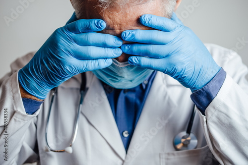 Doctor desperate for rest holding his hands on his head