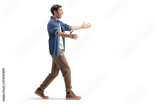 Full length profile shot of an excited young man walking with arms wide open