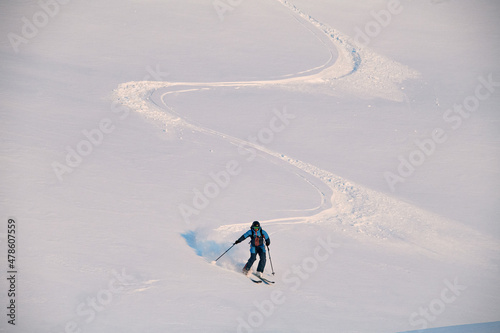 active freerider skilfully rides down white powdery snow of mountain slope