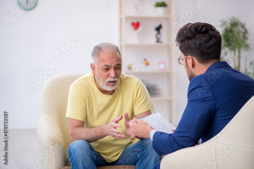 Old man visiting young male psychotherapist