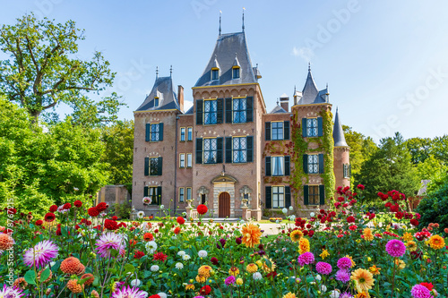 The front view of a beautiful castle with the colorful dahlias in the foreground in a park in Lisse, the Netherlands