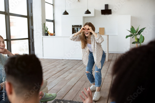 Best friends playing charades in living room, trying to guess correct word on student party