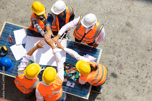 Ethnic diversity worker people, Success teamwork. Group of professional engineering people wearing hardhat safety helmet meeting with solar photovoltaic panels discussion in new project