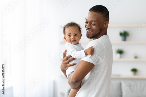Happiness Of Fatherhood. Young black dad with little baby on hands