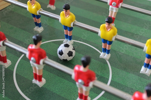 Close up of some players and soccer ball on a foosball table